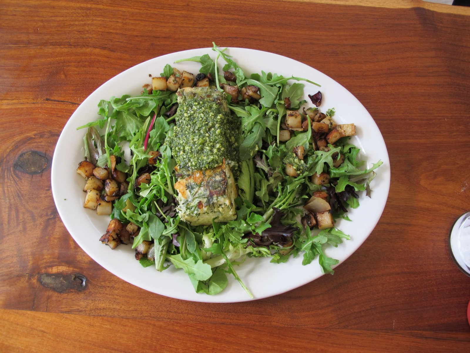 Frittata over organic salad greens with home fries