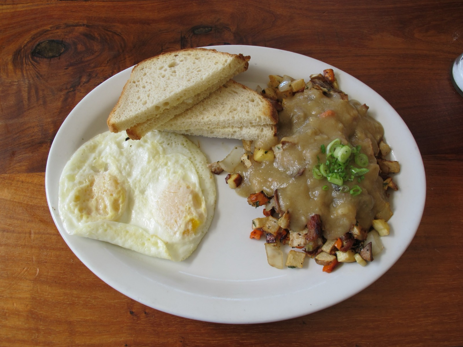 Roast turkey hash smothered in pan gravy with two eggs and toast